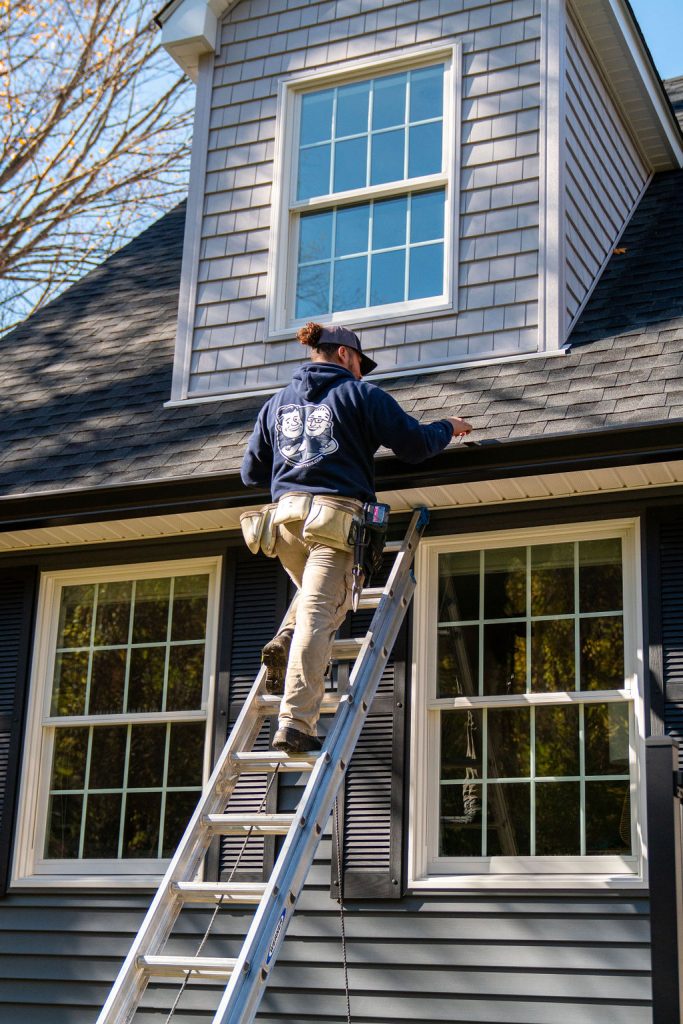 gutter contractor services - technician on a ladder